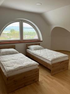 two beds in a room with a window at Ubytovanie pri Kúpeľoch in Bojnice