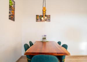 ein Esszimmer mit einem Holztisch und grünen Stühlen in der Unterkunft Apartmenthaus Rankestraße 4 in Dresden