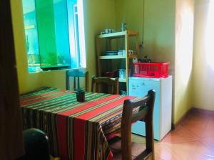 een tafel met een gestreepte tafeldoek en een koelkast bij Emilia house in Urubamba