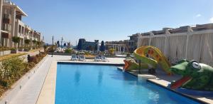 a swimming pool with a slide in a resort at Tulip elite in Ain Sokhna