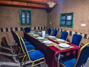 a long table in a room with blue chairs at Café restaurante shelter calm life in Bou Dib +70 photos