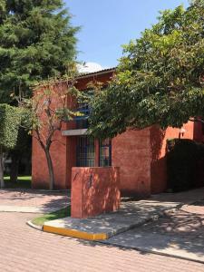 un bâtiment en briques rouges avec un arbre devant lui dans l'établissement MS Suite Amueblada Alberca Blvd B Quintana, à Mendiola