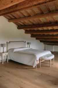 - une chambre avec un lit blanc et un plafond en bois dans l'établissement La Monteduccia, à Ostra Vetere