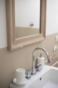 La salle de bains est pourvue d'un lavabo blanc et d'un miroir. dans l'établissement La Monteduccia, à Ostra Vetere