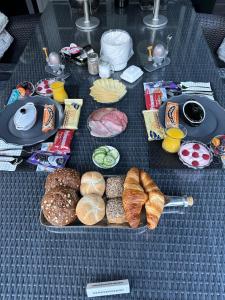 un tavolo con diversi tipi di pane e prodotti da forno di Bed en Breakfast a Epe