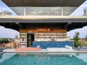 a building with a bar next to a swimming pool at 21 House of Stories Navigli in Milan