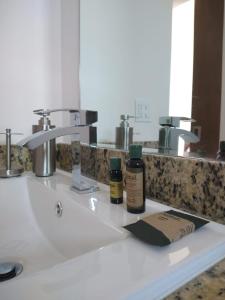 a bathroom sink with two bottles of moisturizers on it at Suite Loft Amplio Nuevo Salida a CDMX 204A in Querétaro +24 photos