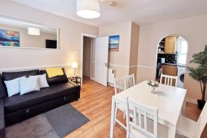 a living room with a black couch and a white table at Spacious 2bed apartment city centre in Dublin