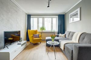 salon z kanapą i telewizorem w obiekcie Little Home Apartments w Warszawie