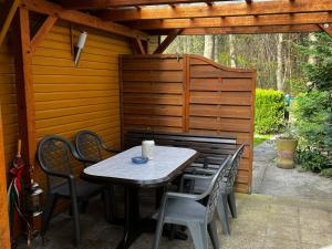 a table and chairs sitting under a wooden pergola at Strand und Waldhaus in Ückeritz Uriges Ambiente trifft Meer in Ueckeritz