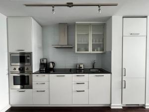 a white kitchen with white cabinets and appliances at Prime Stay Suites in Toronto