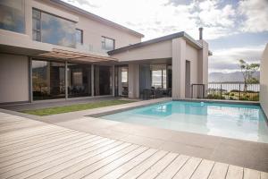 a house with a swimming pool in front of it at Milk and Honey Villa 192 in Hermanus