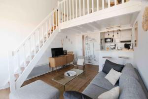 a living room with a couch and a staircase at Le Landifornia - Design cosy & horizon bleu avec vue océan in Seignosse
