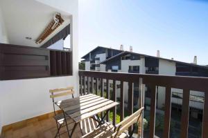 a wooden bench sitting on the balcony of a building at Le Landifornia - Design cosy & horizon bleu avec vue océan in Seignosse