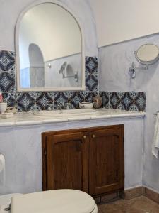 La salle de bains est pourvue de toilettes et d'un miroir. dans l'établissement The Place Yoga Retreat *FREE YOGA CLASS, à Pantelleria