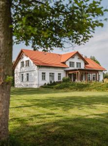 uma grande casa branca com um telhado laranja em Willa Bizorenda em Małogoszcz