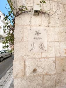 a sign on the side of a stone wall at Stella Marina Luxury in Polignano a Mare
