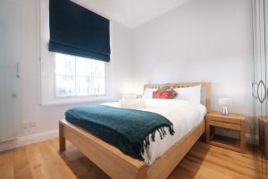 ein Schlafzimmer mit einem großen Bett und einem Fenster in der Unterkunft King's Cross 3BR - CityApartmentStay in London