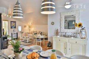 ein Esszimmer und ein Wohnzimmer mit Tisch und Stühlen in der Unterkunft La Vinière - Villa avec piscine in Saint-Hilaire-de-Talmont