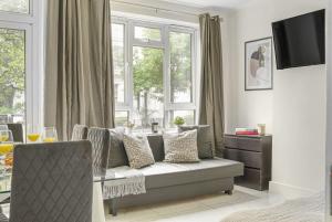 a living room with a couch and a window at Paddington with Balcony - CityApartmentStay in London