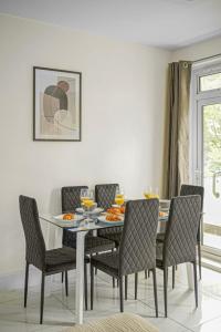 a dining room with a glass table and chairs at Paddington with Balcony - CityApartmentStay in London
