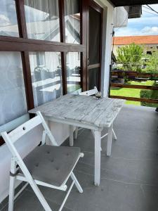 Biały stół i krzesło na ganku w obiekcie Sunset terrace w mieście Ilinden
