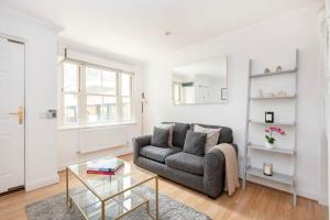 a living room with a couch and a glass table at Old Street - 4BR Townhouse with Patio - CityApartmentStay in London