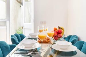 a table with two glasses of wine and a bowl of fruit at Old Street - 4BR Townhouse with Patio - CityApartmentStay in London