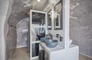 a bathroom with two sinks and mirrors in a tunnel at Hostel 16 Oia in Oia