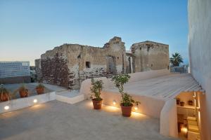 a building with potted plants on the roof at Hostel 16 Oia in Oia