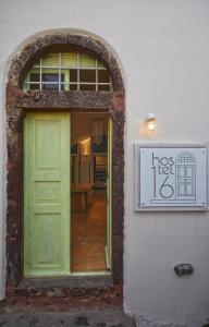 a green door on the side of a building at Hostel 16 Oia in Oia