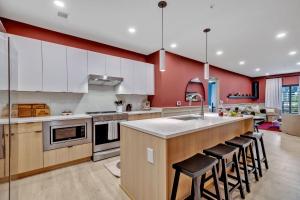 a kitchen with white cabinets and a island with bar stools at Nashville - 635 7th Ave S Unit 412 in Nashville