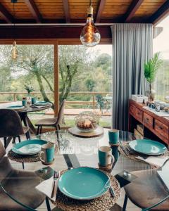 uma sala de jantar com mesas e cadeiras e uma grande janela em Quinta da Relva - Soulful House em Mafra