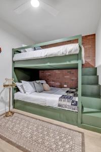 a bedroom with two bunk beds and a brick wall at Nashville - 635 7th Ave S Unit 412 in Nashville