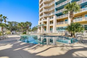 a swimming pool in front of a large building at Charming Condo on the Beach/Legacy T2-1102 in Gulfport