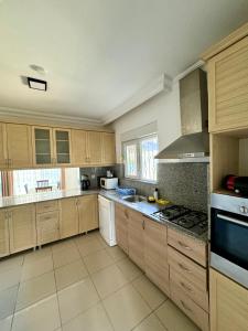 a large kitchen with wooden cabinets and appliances at Anfora Villaları in Belek