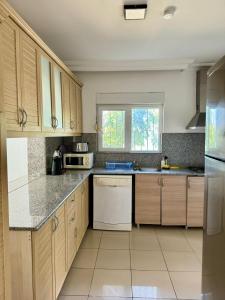 a kitchen with wooden cabinets and white appliances at Anfora Villaları in Belek