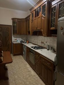cocina con armarios de madera y lavavajillas en Dalan House, en Ereván