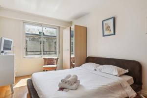 1 dormitorio con 1 cama con 2 toallas en Trocadero & Arc de Triomphe with Balcony - CityApartmentStay, en París
