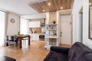 a living room with a table and a kitchen at Champ de Mars & Rue de Grenelle - CityApartmentStay in Paris