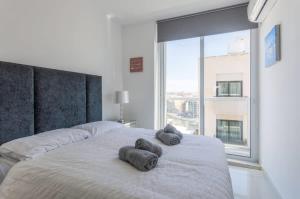 een slaapkamer met een bed met twee handdoeken erop bij Saint Julian - Lovely Apartment with Terrace - CityApartmentStay in St Julian's