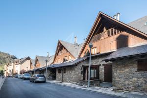 a row of buildings with cars parked on a street at Casa Garona by SeaMount Rentals in Bossost