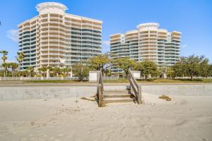 a sandy beach with two tall buildings in the background at Charming Condo on the Beach/Legacy T2-1102 in Gulfport