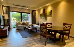 a living room with a couch and a table at Royal L'azure Resort in Sharmaa