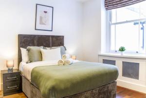 a bedroom with a bed with two teddy bears on it at Notting Hill & Hyde Park - CityApartmentStay in London