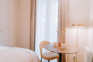 1 dormitorio con mesa, cama y ventana en Apparts' Rennes BnB Duhamel- Centre Gare, en Rennes