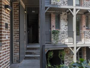 a front porch of a brick house with stairs and plants at Apparts' Rennes BnB Duhamel- Centre Gare in Rennes