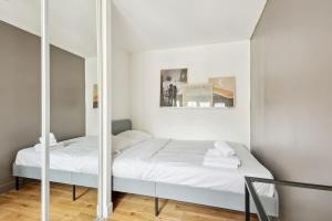 een slaapkamer met 2 bedden en een spiegel bij Les Halles & Le Marais - CityApartmentStay in Parijs