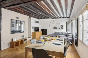 een woonkamer met een tafel en een bank bij Les Halles & Le Marais - CityApartmentStay in Parijs