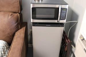 een magnetron bovenop een koelkast naast een stoel bij Guest Area for Rent, Your own space! in Hendersonville